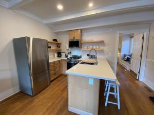a kitchen with a stainless steel refrigerator and wooden floors at Goldsmith's River Front Inn in Missoula