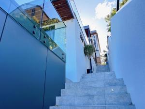 a house with glass walls and concrete stairs at Manly Paradise Apartment in Sydney