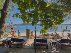 a beach with chairs and people on the beach at Los Vivos Beachfront Experience in Pochote