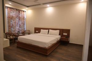 1 dormitorio con cama, mesa y ventana en Hotel Apple Blossom B$B en Manāli