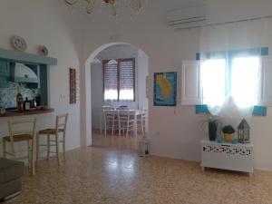Villetta rizzo في Capilungo: مطبخ وغرفة معيشة مع طاولة وكراسي