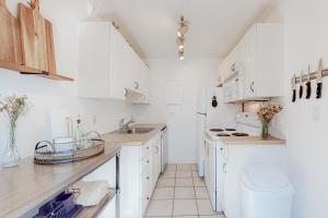 a white kitchen with white cabinets and a sink at Enchanting Elektra #702 in Seattle