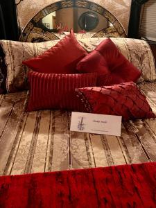 a bed with red pillows and a sign on it at The Oasis in Redding +22 photos