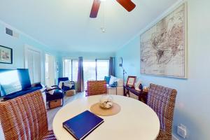 a living room with a table and chairs with a laptop at Hilton Head Resort 2221 in Hilton Head Island