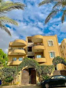 ein gelbes Gebäude mit einem davor geparkt in der Unterkunft فيلا مبهجة مع مسبح وحديقة رائعة in Madinat as-Sadis min Uktubar