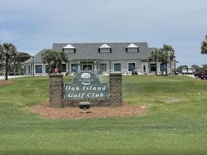 un panneau indiquant le club de golf de l'île de chêne devant un bâtiment dans l'établissement Anchor Inn Motel, à Île au chêne