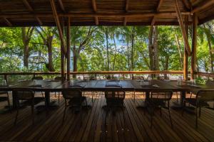 ein großer Tisch auf einer Terrasse mit Bäumen im Hintergrund in der Unterkunft Los Vivos Beachfront Experience in Pochote