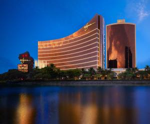 a hotel with a reflection in a body of water at Wynn Macau in Macau