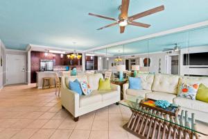 sala de estar con 2 sofás blancos y cocina en Dolphin Point 105A, en Destin