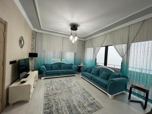 uma sala de estar com dois sofás azuis e uma televisão em Çolakoğlu Konağı em Rize