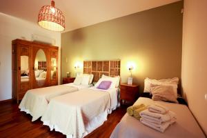 a bedroom with three beds with white sheets at Posada La Victoria in San Rafael