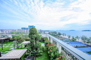 balcón con mesas y sillas y vistas al agua en Sea Breeze Hotel & Villa, en Sihanoukville