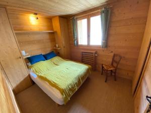 a bedroom in a log cabin with a bed and a chair at Appartement La Clusaz, 4 pièces, 8 personnes - FR-1-459-189 in La Clusaz