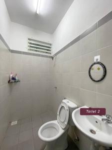 een badkamer met een toilet en een wastafel bij ASFA Guesthouse in Alor Setar