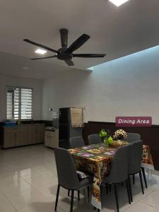 uma área de refeições com uma mesa com cadeiras e uma ventoinha de tecto em ASFA Guesthouse em Alor Setar