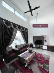 a living room with a couch and a table at ASFA Guesthouse in Alor Setar