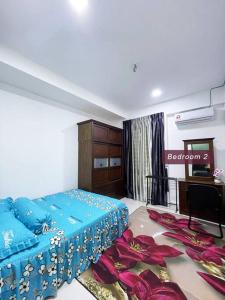 1 dormitorio con 1 cama azul y TV en ASFA Guesthouse en Alor Setar