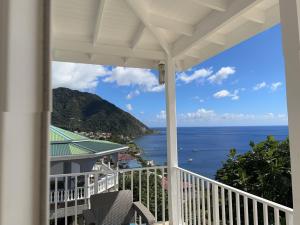 a view of the ocean from the balcony of a house at El Dorado Guest Suites & Car Rental in Roseau