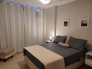 um quarto com uma cama grande e uma cadeira em Apartamento em Niterói - Boa Viagem em Niterói