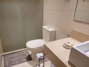 y baño con aseo blanco y lavamanos. en Apartamento em Niterói - Boa Viagem, en Niterói
