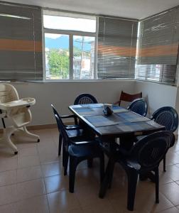 comedor con mesa, sillas y ventana en Apartamento central melgar, en Melgar
