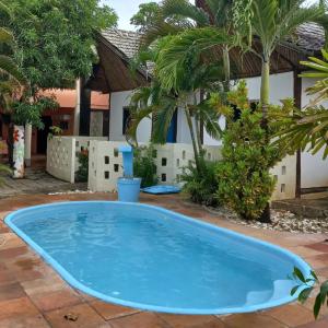 una gran piscina azul frente a una casa en Pousada Mares de Stella en Salvador