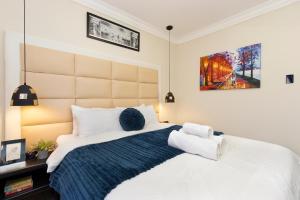 1 dormitorio con 1 cama blanca grande con manta azul en Marigold - No Load Shedding, en Brackenfell