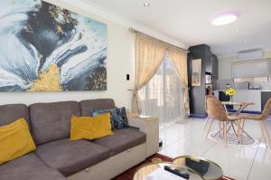 sala de estar con sofá y mesa en Marigold - No Load Shedding, en Brackenfell