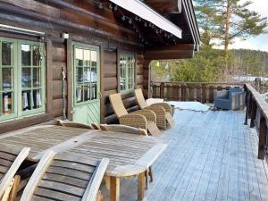 una terraza de madera con sillas y una mesa en una cabaña en 5 person holiday home in Drangedal-By Traum, en Drangedal