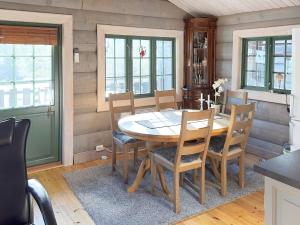 uma sala de jantar com uma mesa de madeira e cadeiras em Holiday home Drangedal II em Drangedal