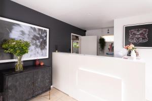 - une cuisine avec un comptoir blanc et des murs noirs dans l'établissement Milano Motor Lodge, à Christchurch