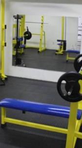 a gym with a blue and yellow bench and weights at Apart Ponta Negra Beach Natal -Lovely Flat in Natal