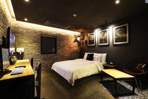 a bedroom with a bed and a table and a tv at Mari Hotel in Cheongju