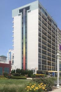 a tall white building with a rainbow at Four Sails Resort in Virginia Beach