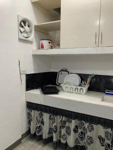 eine Küche mit weißen Schränken und einer Arbeitsplatte in der Unterkunft Romblon Transient House in Romblon
