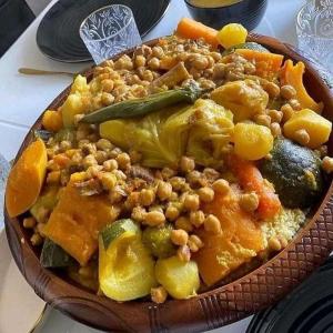 um prato de alimentos com feijão e legumes sobre uma mesa em GITE Take Ur time em Merzouga
