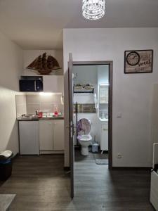 una puerta abierta a una cocina con aseo y lavamanos en studio meublé au RDC , proche lac, en Aix-les-Bains