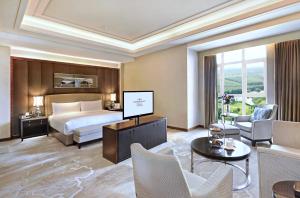 a hotel room with a bed and a tv at Crowne Plaza Tianjin Jinnan, an IHG Hotel in Tianjin