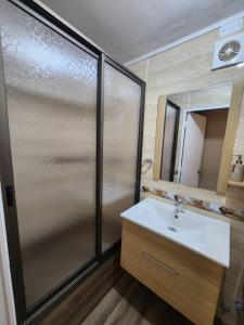 a bathroom with a shower with a sink and a mirror at Departamento en Dichato, 4 personas frente a la playa in Dichato
