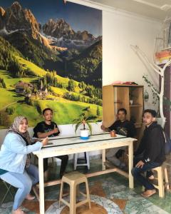 a group of people sitting around a table in a room at Ohana Homestay Banyuwangi in Banyuwangi