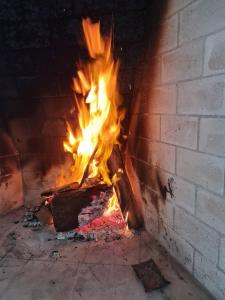 um fogo num forno de tijolos com chamas nele em Casa Areal, 1 Suíte, 2 quartos, piscina garagem para 2 carros em Pelotas