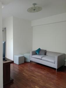 een woonkamer met een bank en een tv bij Romina's Home in Lima