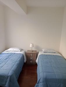 twee bedden naast elkaar in een slaapkamer bij Romina's Home in Lima
