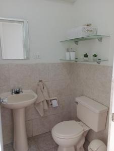 y baño con aseo blanco y lavamanos. en Romina's Home, en Lima