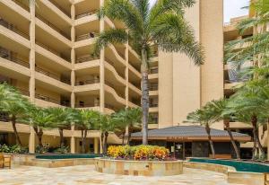 un gran edificio con palmeras delante en Polo Beach Club One Bedrooms by Coldwell Banker Island Vacations en Wailea