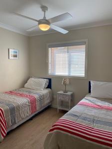 a bedroom with two beds and a ceiling fan at The Sands in Mollymook