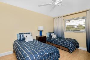 a bedroom with two beds and a ceiling fan at Hidden Gem 813 in Naples +17 photos