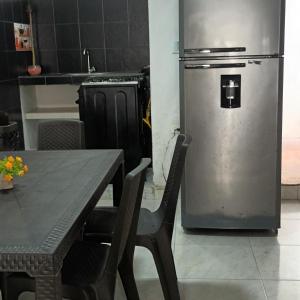 a kitchen with a table and a refrigerator at Girasoles Tolu in Santiago