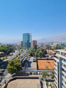 a city with cars parked in a parking lot at Departamentos Pontoni Manquehue in Santiago