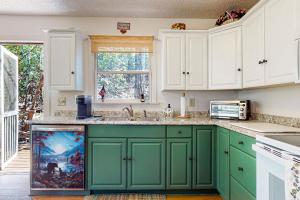 亨德森維爾的住宿－Brook Hollow，绿色厨房配有白色橱柜和水槽